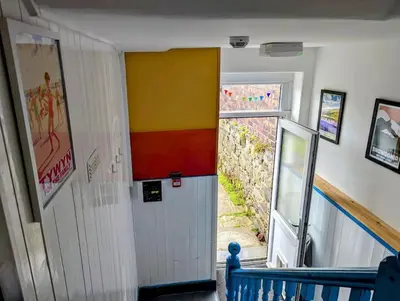 a hallway with a white door and a colorful wall at Family Home in Tywyn - Game and Cinema Rooms in Tywyn