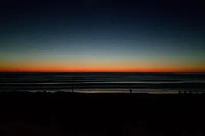 a sunset on a beach with the ocean at Family Home in Tywyn - Game and Cinema Rooms in Tywyn