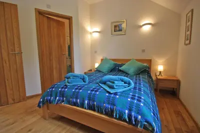 a bedroom with a bed with blue towels on it at Henllys Lodge in Cilycwm