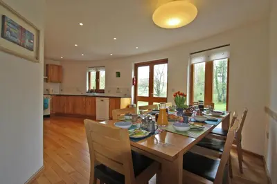 a dining room with a wooden table and chairs at Henllys Lodge in Cilycwm