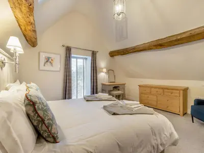 a bedroom with a large white bed and a blue chair at Hares Hollow - Uk33953 in Llanymynech