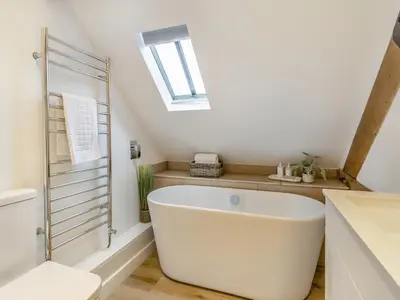 a bathroom with a large white tub and a skylight at Hares Hollow - Uk33953 in Llanymynech