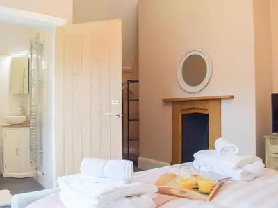 a room with a bed with towels and glasses of orange juice at The Woodshed in Letton