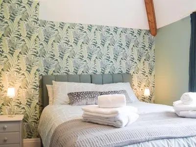 a bedroom with a bed with towels on it at The Woodshed in Letton