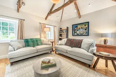 a living room with two couches and a table at Ty Glyn Mansion Cottage in Ciliau-Aeron