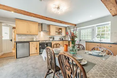 a kitchen with a table and chairs in a kitchen at Ty Glyn Mansion Cottage in Ciliau-Aeron