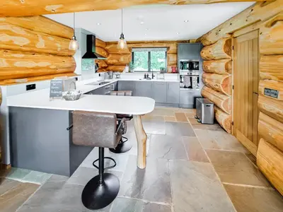 a kitchen with wooden walls and a white table in a room at Hope Hideaway in Leighton