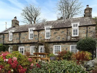 an old stone house with a garden in front of it at Bryn Hyfryd in Harlech