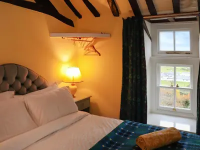 a bedroom with a bed and a window at Bryn Hyfryd in Harlech