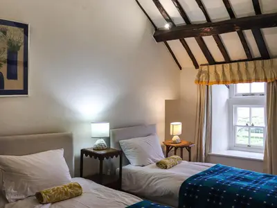 a bedroom with two beds and a window at Bryn Hyfryd in Harlech