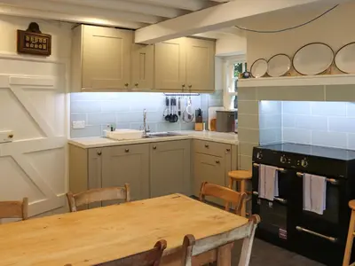 a kitchen with a table and a stove top oven at Bryn Hyfryd in Harlech