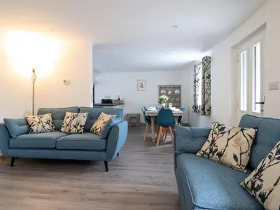 a living room with two blue couches and a table at Bwthyn Camlan in Machynlleth
