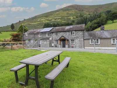 a picnic bench sitting in front of a building at Bwthyn Camlan in Machynlleth