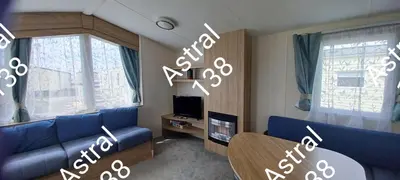 a living room with a blue couch and a tv at Astral 138 snowdon summit 098 in Barmouth