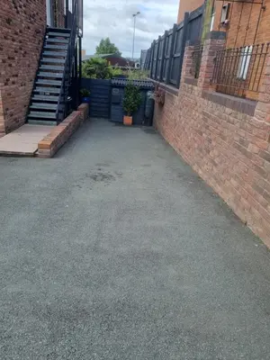 an empty parking lot between two brick buildings at 1-Bed Apartment - Sleeps 2 & Private Parking in Llansantffraid-ym-Mechain