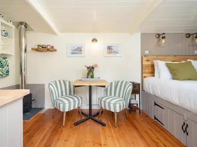 a bedroom with a bed and a table and two chairs at Collen in Llanarth