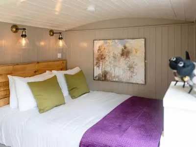 a bedroom with a large white bed with green pillows at Collen in Llanarth