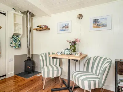 a room with two chairs and a table and a stove at Collen in Llanarth