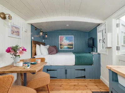 a bedroom with blue walls and a bed in a room at Bedwen in Llanarth