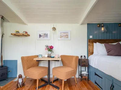 a bedroom with a bed and a table with two chairs at Bedwen in Llanarth