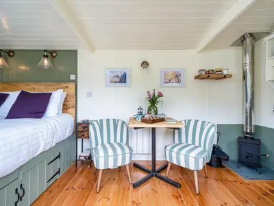 a bedroom with a bed and a table and two chairs at Onnen in Llanarth