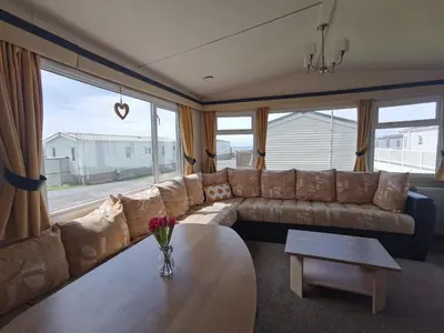 a living room with a couch and a table at Snowdonia Holiday Sea Beach and Mountains view in Llwyngwril