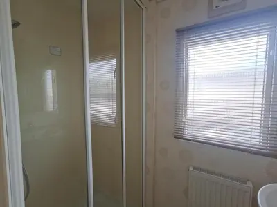 a bathroom with a shower and a sink and a mirror at Snowdonia Holiday Sea Beach and Mountains view in Llwyngwril