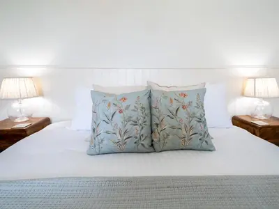 a white bed with two pillows and two lamps at School House Victorian elegance by the river with parking Pass the Keys in Shrewsbury