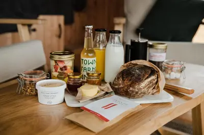 a table with a loaf of bread and bottles of milk at The Bulls Head Wild Cabins in Hereford