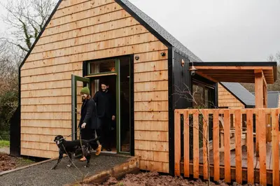 a man walking a dog into a tiny house at The Bulls Head Wild Cabins in Hereford