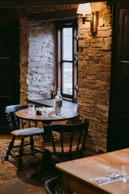 a restaurant with two tables and chairs and a window at The Bulls Head Wild Cabins in Hereford