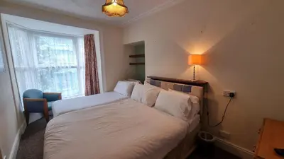 a bedroom with a bed and a lamp and a window at Morawel in Aberystwyth