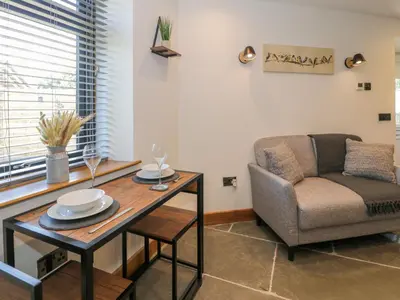 a living room with a table and a chair at Y Bwthyn in Dolgellau