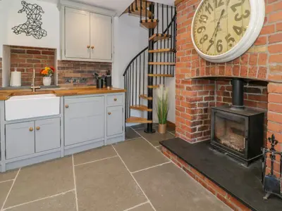 a kitchen with a fireplace and a clock on the wall at Y Bwthyn in Dolgellau