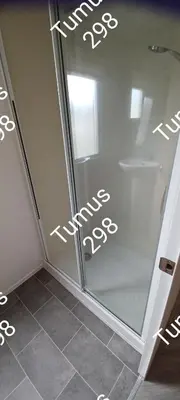 a bathroom with a shower and a glass door at Tumus 298 sandy cove 066 in Barmouth