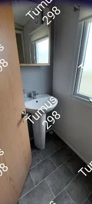 a bathroom with a sink and a mirror at Tumus 298 sandy cove 066 in Barmouth