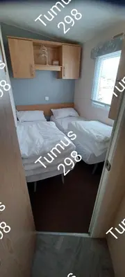 two beds in a small room with lights on the ceiling at Tumus 298 sandy cove 066 in Barmouth