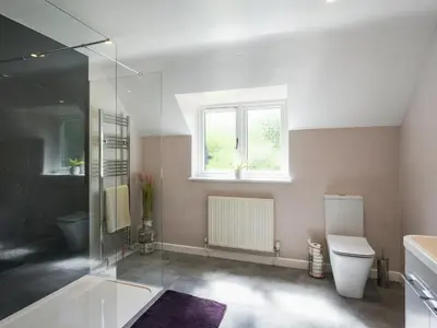 a bathroom with a shower and a toilet and a window at The Lodge At Harvest Farm in Ludlow