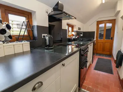 a kitchen with a counter top and a stove top oven at Aelybryn in Oswestry