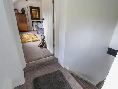 a teddy bear sitting in the middle of a hallway at Aelybryn in Oswestry