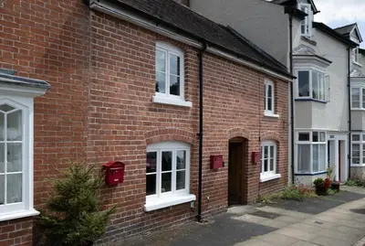 a brick house with a christmas tree in front of it at Grade 2 Cottage 1 bedroom, Ludlow centre in Ludlow