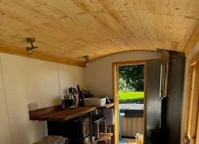 a kitchen with a wooden ceiling and a counter at Little Dolwen - Sioned in Llanwenog
