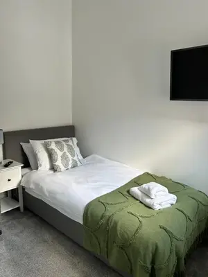 a bedroom with a bed with a tv on the wall at Cottage in Ludlow in Ludlow