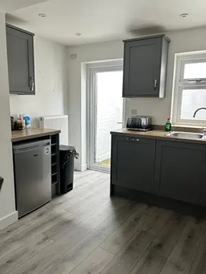 a kitchen with black cabinets and a wooden floor at Cottage in Ludlow in Ludlow