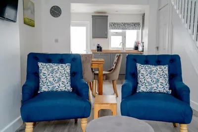 two blue chairs in a living room with a table at Cottage in Ludlow in Ludlow