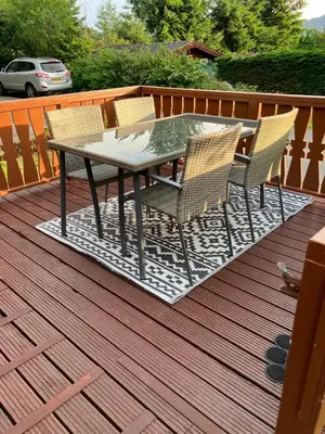 a patio table and chairs on a deck at Snowdonia luxury log cabin in Trawsfynydd