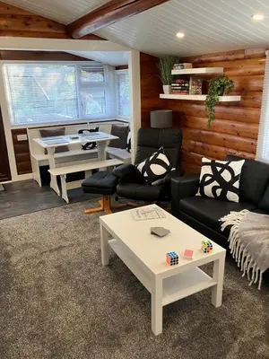 a living room with a couch and a table at Snowdonia luxury log cabin in Trawsfynydd