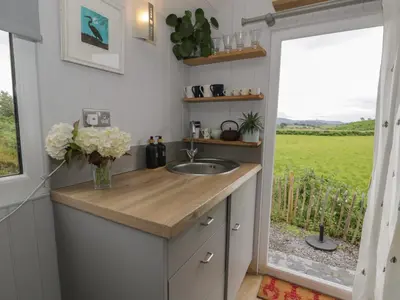 a small kitchen with a sink and a window at Shepherd's Hut at Penrallt Goch in Blaenau-Ffestiniog