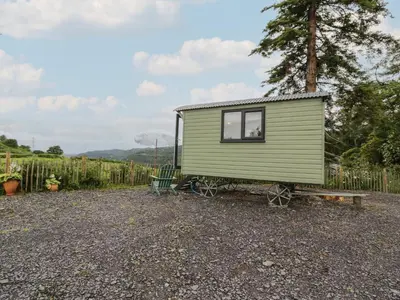 a green tiny house sitting on a trailer at Shepherd's Hut at Penrallt Goch in Blaenau-Ffestiniog