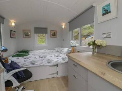a small bedroom with a bed and a sink at Shepherd's Hut at Penrallt Goch in Blaenau-Ffestiniog